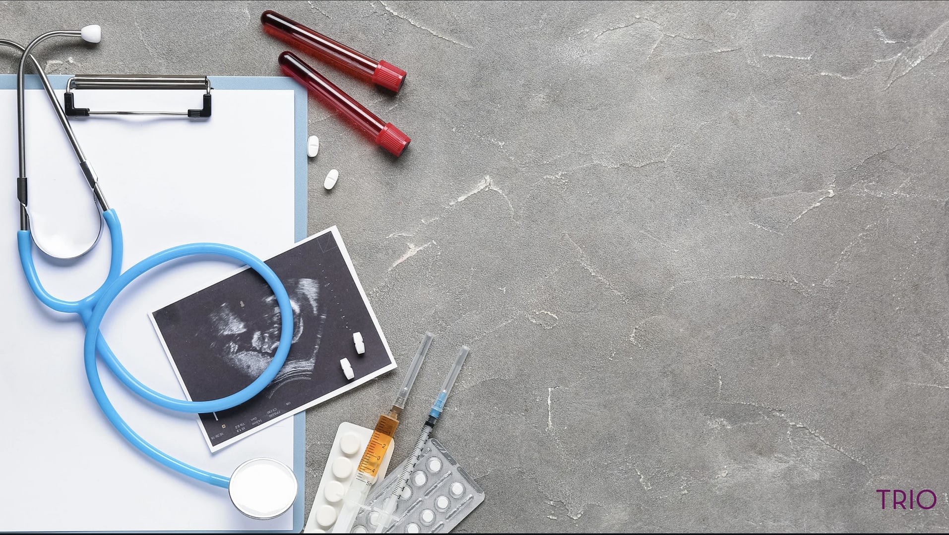 Ultrasound image, stethoscope, pills, drawn blood, and syringes on top of a medical chart.